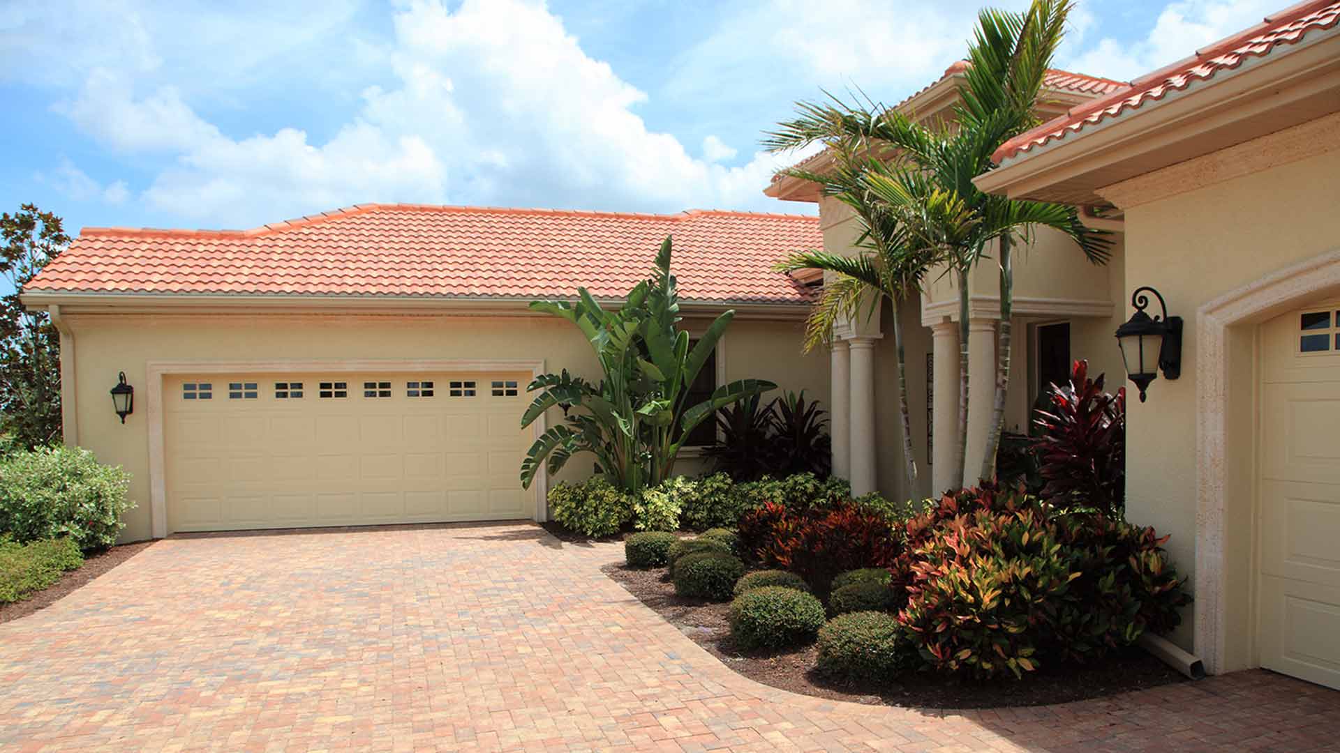 Yellow ranch house with well maintained landscaping beds.